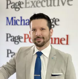 Hombre de traje frente a un letrero de empresas de consultoría.