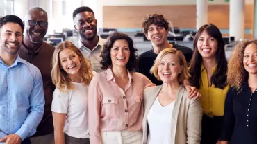 Grupo diverso de personas sonriendo en una oficina.