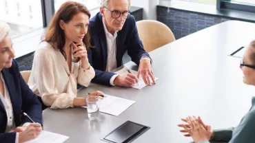 Entrevista laboral con cuatro personas en una mesa.