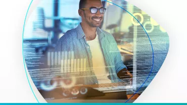 Hombre sonriendo frente a una computadora, rodeado de gráficos y textos digitales.