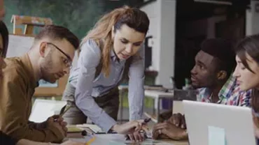 Grupo de personas colaborando en una mesa de trabajo.