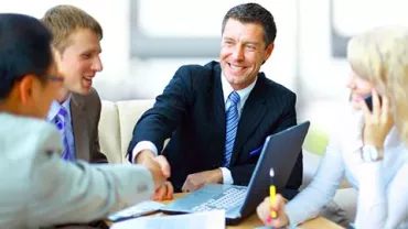 Personas en una reunión de negocios estrechando manos.