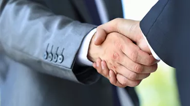Dos personas dándose la mano en señal de acuerdo.
