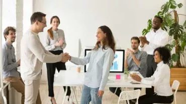 Personas dando la mano en una reunión de oficina.