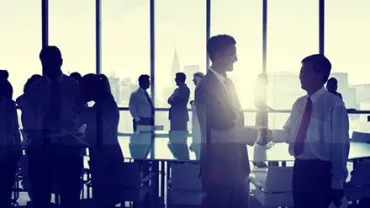 Personas de negocios estrechando manos en una sala de conferencias.