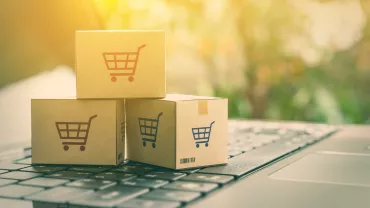 Cajas de cartón con símbolo de carrito sobre un teclado.