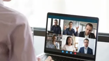 Persona participando en una videollamada grupal desde un ordenador portátil.
