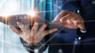 Persona usando tableta con gráficos y números superpuestos.
