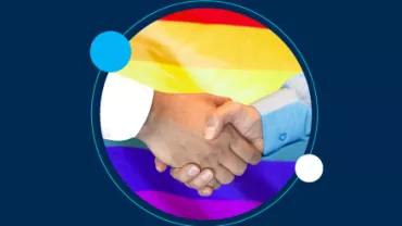 Dos manos estrechándose con una bandera LGBT de fondo.