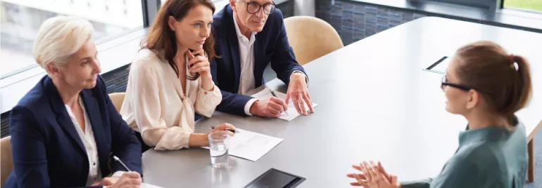 Entrevista laboral con cuatro personas en una mesa.