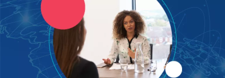 Mujer hablando en una reunión con fondo azul y círculos.