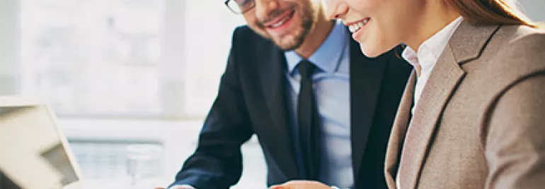 Dos personas revisando información en una tablet en una oficina.
