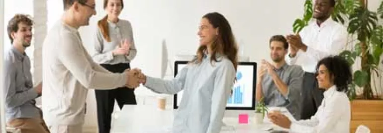 Personas dando la mano en una reunión de oficina.