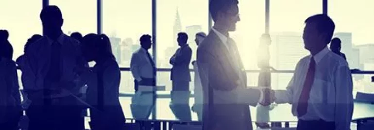 Personas de negocios estrechando manos en una sala de conferencias.