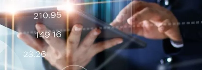 Persona usando tableta con gráficos y números superpuestos.