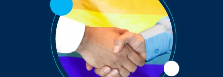 Dos manos estrechándose con una bandera LGBT de fondo.