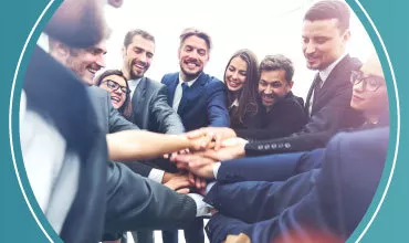 Grupo de personas uniendo sus manos en señal de trabajo en equipo.