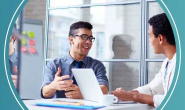Dos personas conversando en una oficina moderna.