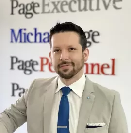Hombre de traje frente a un letrero de empresas de consultoría.