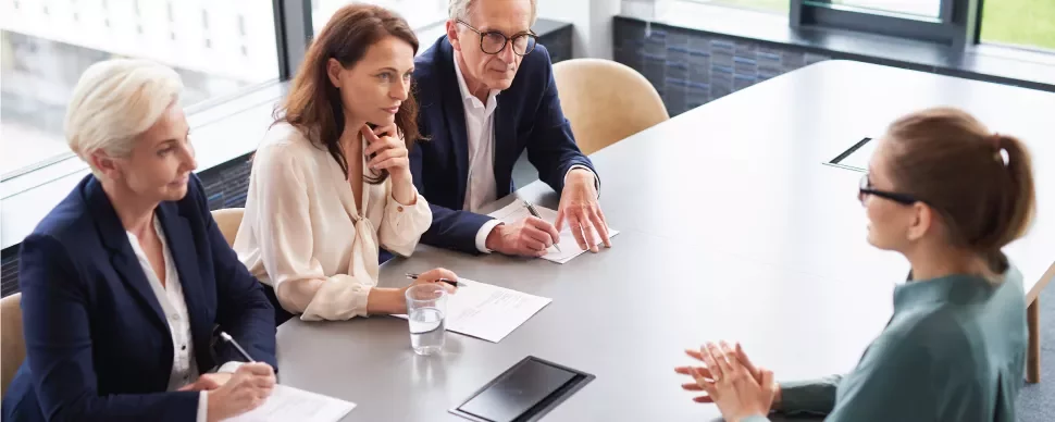 Entrevista laboral con cuatro personas en una mesa.