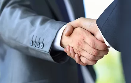 Dos personas dándose la mano en señal de acuerdo.